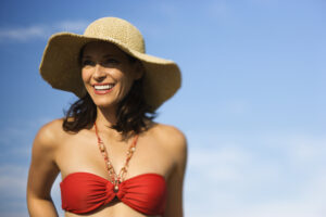 Middle aged woman in red swimsuit has smooth skin around her neck and upper chest thanks to BodyTite.